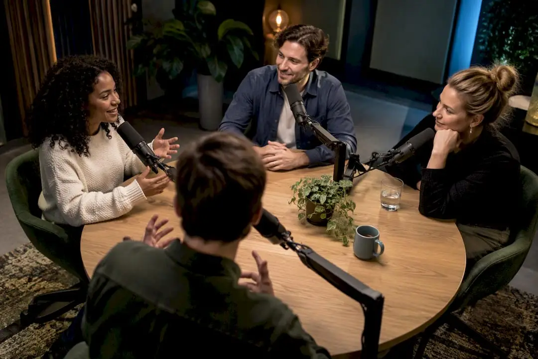 Vier Personen in einem professionellen Podcast-Studio